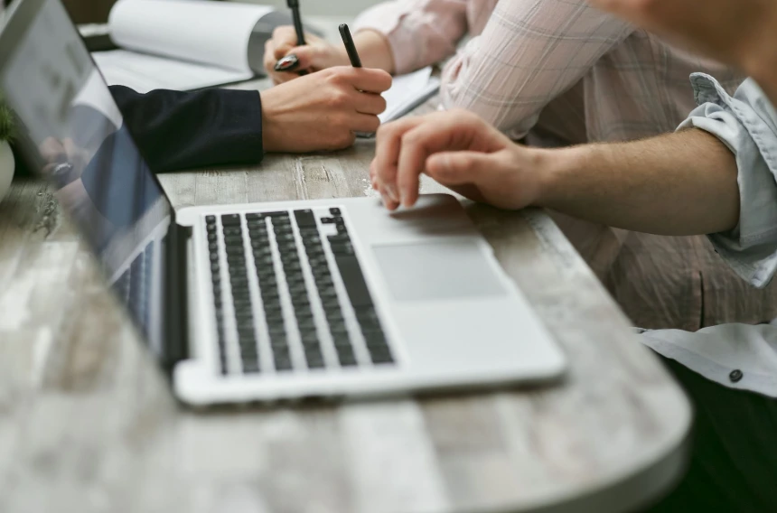 People working on a laptop, discussing Admin access